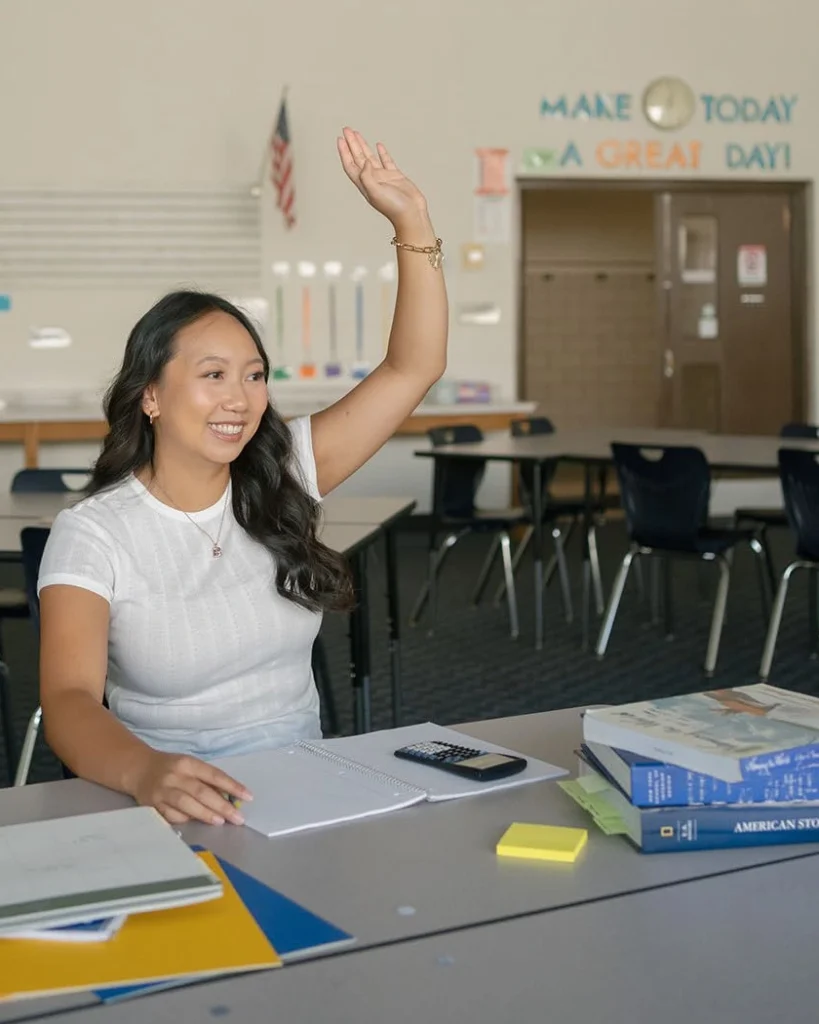 A student raises a hand in a classroom.