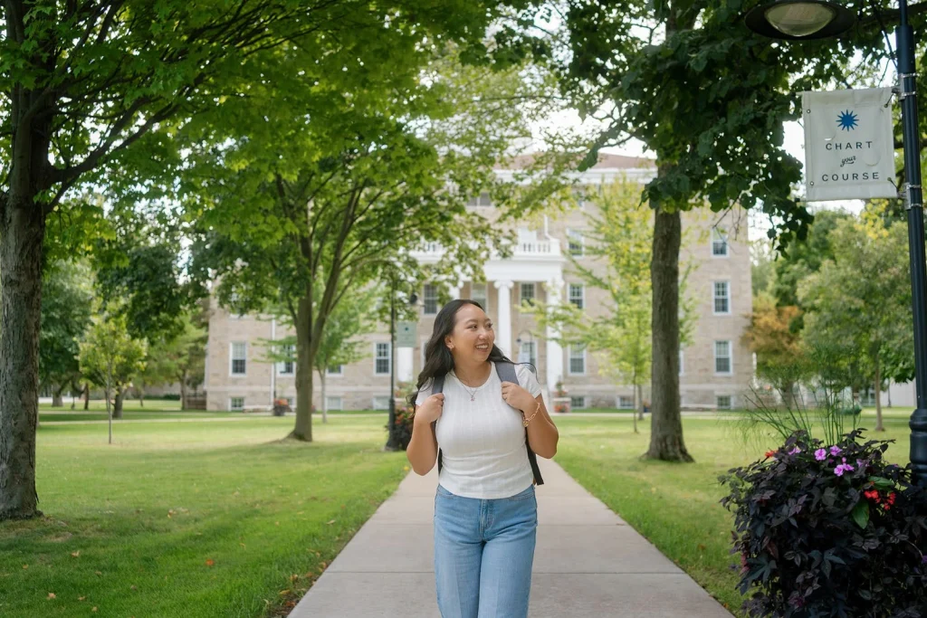 A student explores a tree-lined college campus.