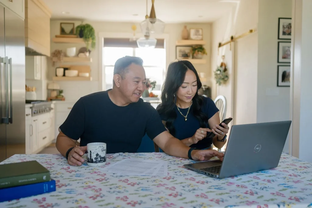An adult and a student review information on a laptop.