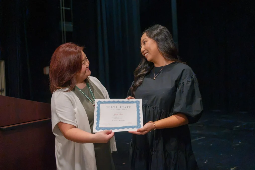 A student receives a certificate on a stage.